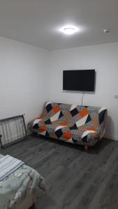 a living room with a couch and a flat screen tv at Double Bedroom with private bathroom and shared kitchen in Oldbury