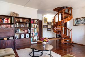 a living room with a spiral staircase and a table at Casa da Lena in Batalha