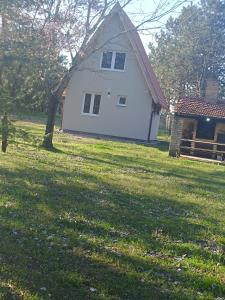 a white house in the middle of a field at Vikendica Kelebija in Subotica