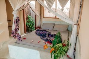 a bed in a room with a window at Marvelous Zanzibar in Jambiani