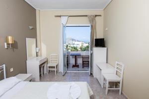 1 dormitorio con cama, escritorio y mesa en Hotel Venetia, en Perdika