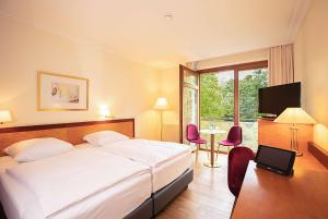 a hotel room with a bed and a table with chairs at Dolce by Wyndham Bad Nauheim in Bad Nauheim