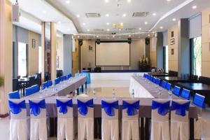 una sala conferenze con un lungo tavolo e sedie blu di The Par Phuket SHA Plus a Kathu