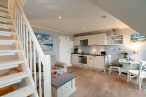 a kitchen and a living room with a staircase at Kleine Buhne in Wenningstedt