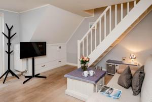 a living room with a couch and a tv at Kleine Buhne in Wenningstedt