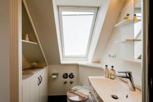 a bathroom with a sink and a window at Kleine Buhne in Wenningstedt +36 photos