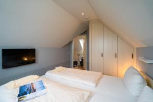 1 Schlafzimmer mit 2 Betten und einem TV an der Wand in der Unterkunft Kleine Buhne in Wenningstedt-Braderup