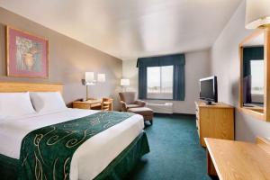 a hotel room with a bed and a television at Travelodge by Wyndham Yermo in Yermo