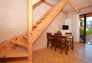 escalera de madera en una habitación con mesa y sillas en Sunny Apartament FizjoSPA & Sport Darłówko Zachodnie ul Kotwiczna-Marynarska 9, en Darłowo