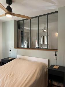 - une chambre avec un lit et un miroir mural dans l'établissement La Grange de Paulette, à Bédoin