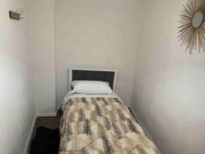 małą sypialnię z łóżkiem w białej ścianie w obiekcie Traditional Bazaar Home2 w mieście Korcza