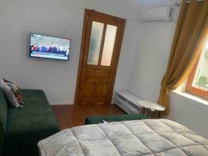 a bedroom with a bed and a tv on the wall at Traditional Bazaar Home2 in Korçë