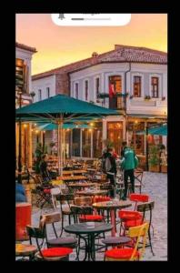 un café en plein air avec des tables, des chaises et des parasols dans l'établissement Traditional Bazaar Home2, à Korçë