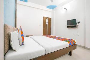 1 dormitorio con 1 cama y TV en la pared en FabHotel Skylon, Near Mahatma Mandir, en Pethāpur