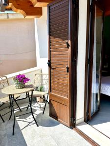 a door to a patio with a table and flowers at 4Rooms in Palermo