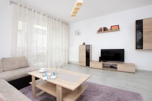 a living room with a couch and a table at Elegant Apartment Myśliwskie Wzgórze in Gdańsk by Renters in Gdańsk