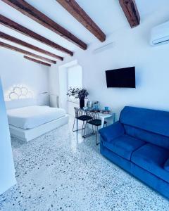 un soggiorno con divano blu e tavolo di Hydria guest house art gallery ad Acquaviva delle Fonti