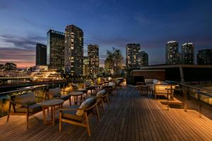 una terraza con sillas y mesas y un perfil urbano en Hilton Yokohama, en Yokohama