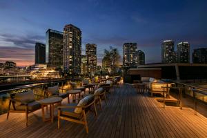 a deck with chairs and tables and a city skyline at Hilton Yokohama in Yokohama