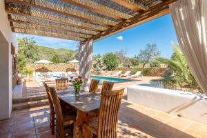 a patio with a table and chairs and a swimming pool at Can White in Sant Carles de Peralta