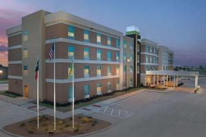 ein großes Gebäude mit zwei Flaggen davor in der Unterkunft Home2 Suites By Hilton Abilene Southwest in Abilene