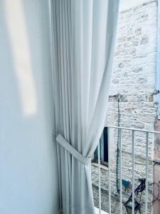 a window with a white curtain and a balcony at Hydria guest house art gallery in Acquaviva delle Fonti