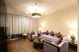 uma sala de estar com um sofá e uma televisão em Landmark Premier Hotel em Dubai