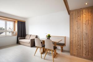 een woonkamer met een tafel en stoelen en een bank bij Snooze Apartments in Holzkirchen