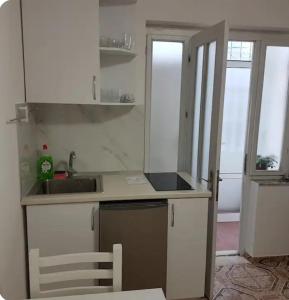 a small kitchen with white cabinets and a sink at New Studio in Pogradec