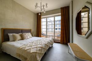 利耶帕亚Bankhaus Apartments的一间卧室，里面有一张床和一扇大窗户。