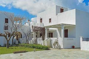 un edificio blanco con un árbol delante en HORIZON Skyrian house, en Skiros