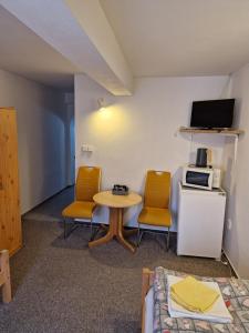 a room with a table and two chairs and a microwave at Pension U Martina in Domažlice