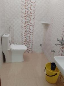 een badkamer met een wit toilet en een wastafel bij YESH PALACE HOMESTAY in Khajurāho