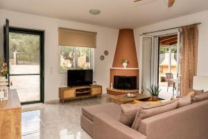 ein Wohnzimmer mit Sofa und Fernseher in der Unterkunft Villa Azra in Zakynthos