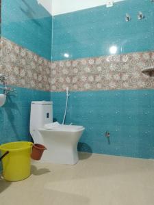 een blauwe badkamer met een toilet en een wastafel bij YESH PALACE HOMESTAY in Khajurāho