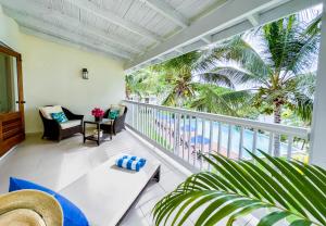 een balkon met uitzicht op de oceaan en palmbomen bij The Hideaway Suite 1512 Pool and Sea views in Gaynors