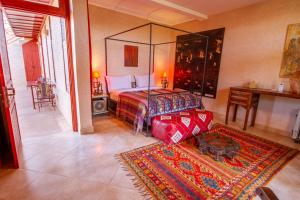 una camera con un letto e una stanza con un tappeto di La Ferme de LallaDom a Tameslouht