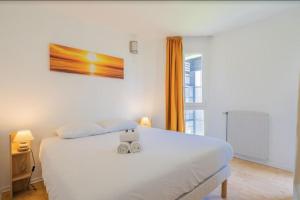 Un dormitorio con una cama blanca con una caja. en L'Horizon, T3, Terrasse, Pkg, Quartier Antigone, en Montpellier