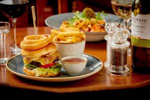 a plate with a sandwich and french fries on a table at The Glengower in Aberystwyth