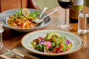 a table with two plates of food and a glass of wine at The Glengower in Aberystwyth