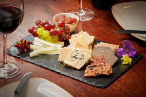 a plate of cheese and grapes and a glass of wine at The Glengower in Aberystwyth