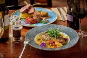a table with two plates of food and a glass of wine at The Glengower in Aberystwyth