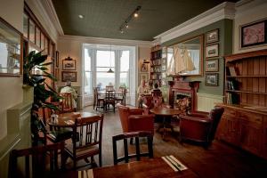 a restaurant with tables and chairs and a fireplace at The Glengower in Aberystwyth