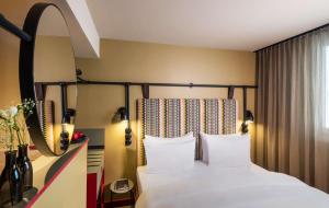 ein Hotelzimmer mit einem Bett mit weißen Kissen in der Unterkunft me and all hotel Berlin east side, part of JdV by Hyatt in Berlin