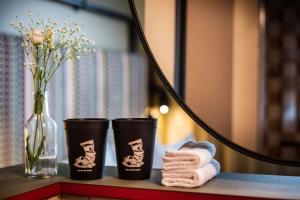 - une table avec des serviettes et un vase de fleurs dans l'établissement me and all hotel Berlin east side, part of JdV by Hyatt, à Berlin