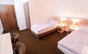 une chambre d'hôtel avec deux lits et deux chaises dans l'établissement Pałac nad Jeziorem, à Chociwel