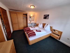 a bedroom with a bed with two red pillows at Pferdehof Oberegg in Werfenweng