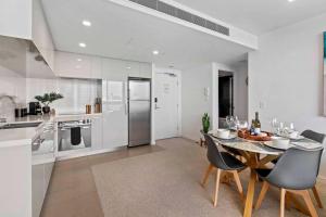a kitchen and dining room with a table and chairs at Cozy 2 bed Retreat Milton - Pool, Walk to SStadium in Brisbane