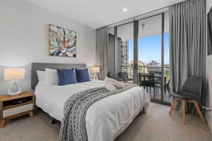 sypialnia z dużym łóżkiem i balkonem w obiekcie Cozy 2 bed Retreat Milton - Pool, Walk to SStadium w mieście Brisbane
