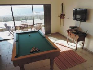 a living room with a pool table and a television at Blue Mountain Bay in Simonʼs Town